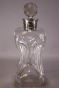 A silver mounted glass spirit decanter with faceted stopper, the decanter of compressed form,