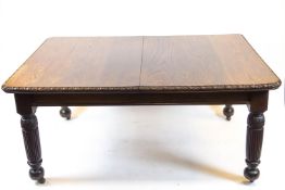 An oak rectangular extending dining table, carved with egg and dart edge,