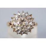 A yellow metal three tier cluster ring set with colourless cubic zirconia.