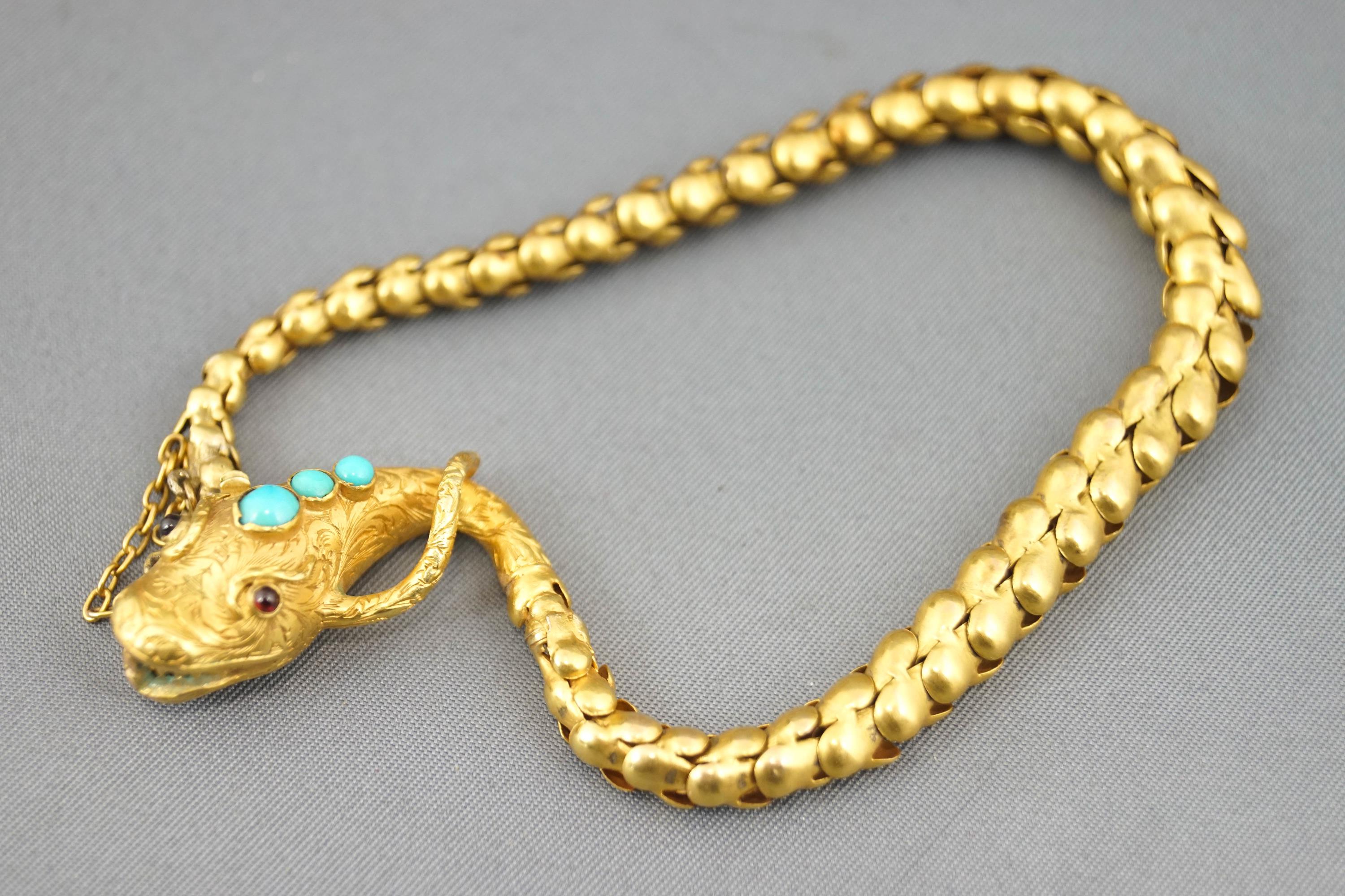 A yellow metal bracelet in the design of a snake.