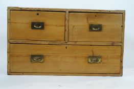 A pine chest of two short and one long drawers, with iron bound corners and inset handles,