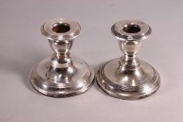 A pair of loaded silver squat form baluster candlesticks with reeded decoration, Birmingham 1912,