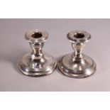 A pair of loaded silver squat form baluster candlesticks with reeded decoration, Birmingham 1912,