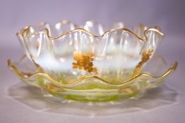 An opaline and gilt glass finger bowl and stand, of frilled form, gilt with rose sprays,