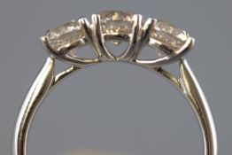 A white metal half hoop ring. Set with three round brilliant cut diamonds.