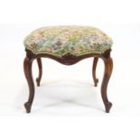 A Victorian mahogany stool, of scroll outline, with stuff over seat, on four cabriole legs,