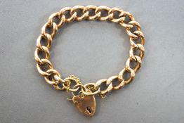 A rose metal large link curb bracelet with padlock and safety chain.