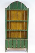 A painted pine bookcase, with arched plank back panel above two shelves,