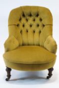 A Victorian button back chair on turned tapering legs and casters,