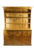 A 20th century pine dresser, the base with three drawers above three conforming panelled doors,