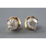 A white metal pair of single stone stud earrings.