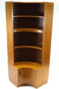 A G-plan teak convex corner cupboard, with three shelves above a cupboard,