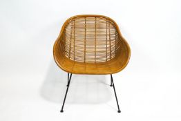 A rattan armchair, circa 1960, on four black lacquered metal legs,