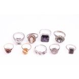 A collection of nine dress rings of mixed metals and variable designs.