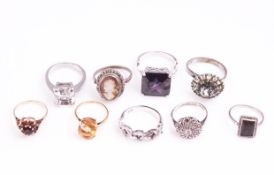 A collection of nine dress rings of mixed metals and variable designs.