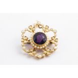 A yellow metal cluster pendant principally set with a round faceted cut amethyst