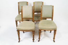 A set of four oak framed chairs by Maple and Co with upholstered backs and seats