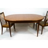 A G-plan teak extending dining table with integral leaf, deep frieze on tapering legs,