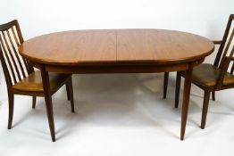 A G-plan teak extending dining table with integral leaf, deep frieze on tapering legs,