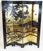 A Japanese Japanned four fold screen, decorated with birds in a landscape on a gilt ground,