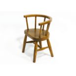 An elm child's chair, with convex spindle back, on turned plain legs and stretchers,