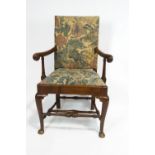 An 18th century walnut provincial armchair, with carved scroll arm,