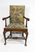 An 18th century walnut provincial armchair, with carved scroll arm,