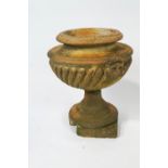 A terracotta garden urn of gadrooned form with lion's masks,