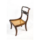 A Regency mahogany and bergere nursing chair with rope twist back rail over an open splat