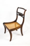 A Regency mahogany and bergere nursing chair with rope twist back rail over an open splat