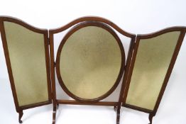 A mahogany framed triptych dressing table with oval swing frame central section on flared feet,