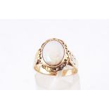 A yellow metal single stone ring set with an oval cabochon opal