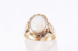 A yellow metal single stone ring set with an oval cabochon opal