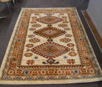 A handmade rug, with three hooked medallions on a beige ground within multiple borders,