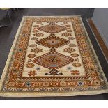 A handmade rug, with three hooked medallions on a beige ground within multiple borders,