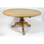 An elm round kitchen table on baluster support on three cabriole legs,