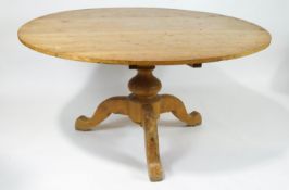 An elm round kitchen table on baluster support on three cabriole legs,