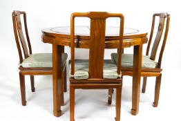 A Chinese rosewood extendable circular dining table with six dining chairs and 2 carvers,