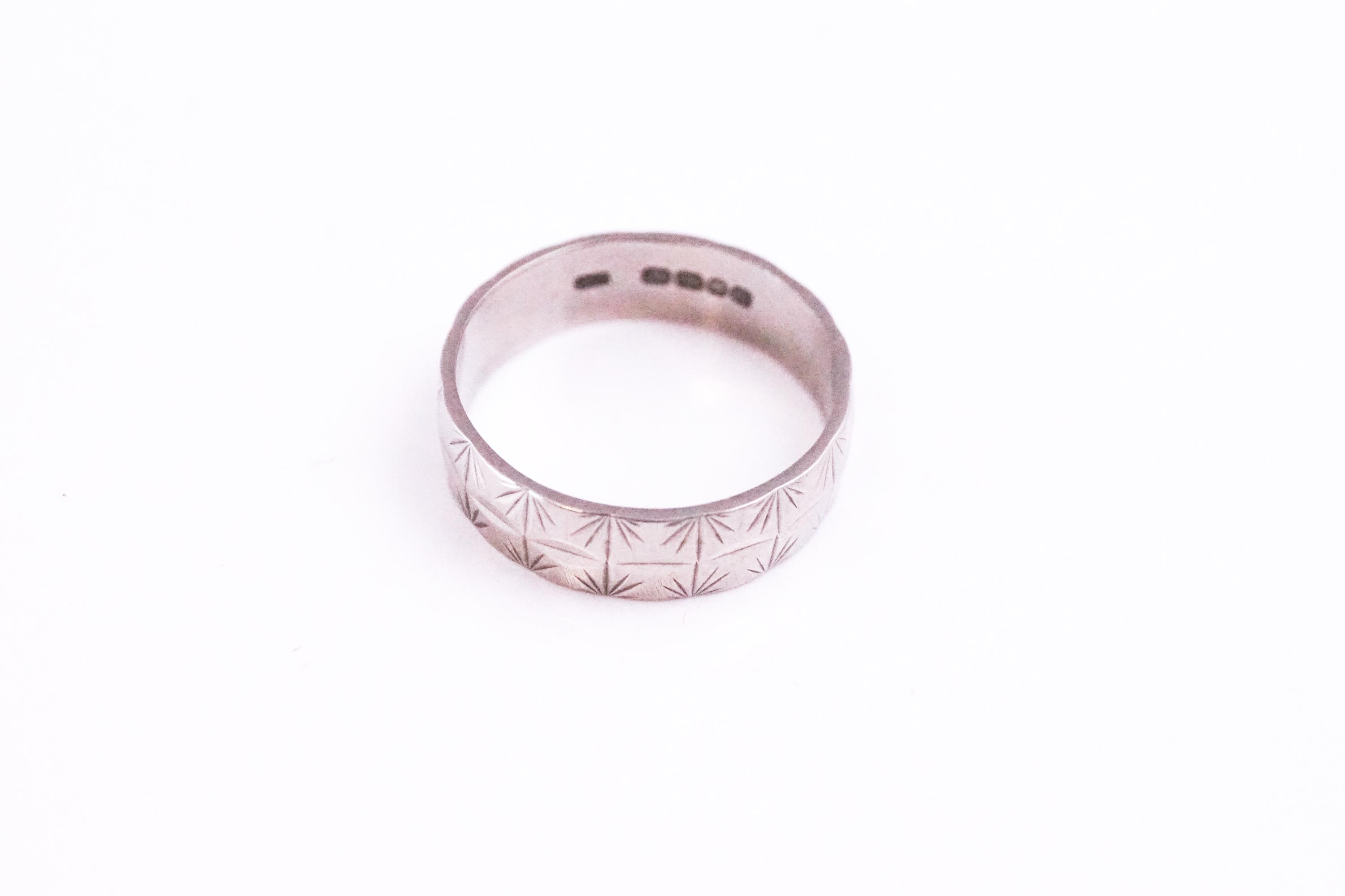 A white metal 5.5mm wedding ring with engraved design. Hallmarked 18ct gold, London, 1969.