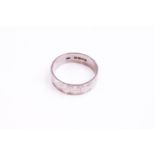 A white metal 5.5mm wedding ring with engraved design. Hallmarked 18ct gold, London, 1969.