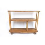 An Ercol light elm three tier shelving unit/bookcase, on castors,