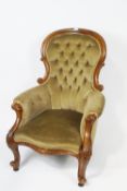 A Victorian mahogany show frame armchair with button back on carved cabriole legs,