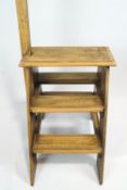 A set of stripped oak library steps, of A-frame construction, with turned upright handrail,
