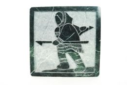 An Inuit carved hardstone panel, by David Bernett, depicting the profile of a hunter 18cm x 18cm,