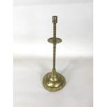 A late 18th/ early 19th century brass candlestick with flared drip pan