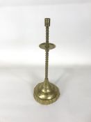 A late 18th/ early 19th century brass candlestick with flared drip pan