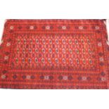 A hand knotted organic red dyed Bukhara rug,