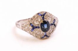 A white metal dress ring. Principally set with and oval faceted cut sapphire.