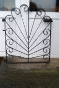 A wrought iron gate in a contrived sunburst design,