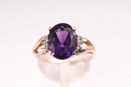 A yellow metal single stone ring set with an oval faceted cut amethyst